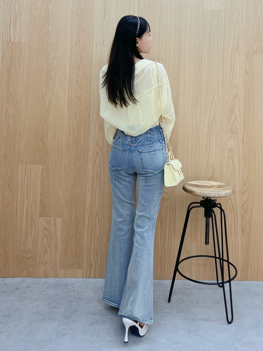 ホワイト系のサンダル、ブルー系のデニムパンツ、イエロー系のハンドバッグを着用したレディースの春コーディネートの3枚目の写真