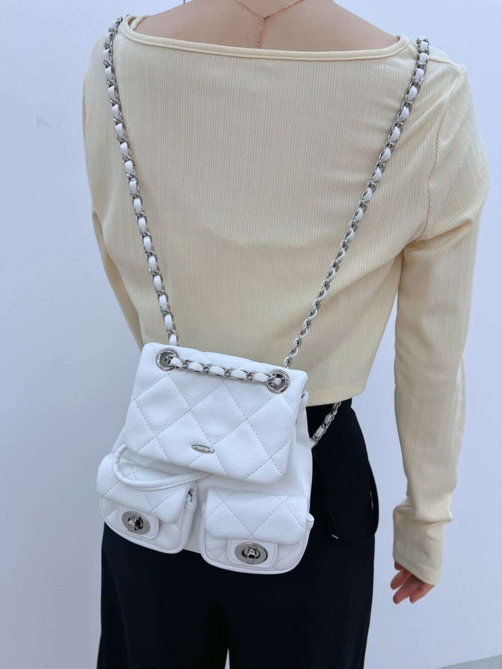 ホワイト系のバックパック/リュック、ブラック系のその他パンツ、ブラック系のサンダルを着用したレディースの春コーディネートの6枚目の写真