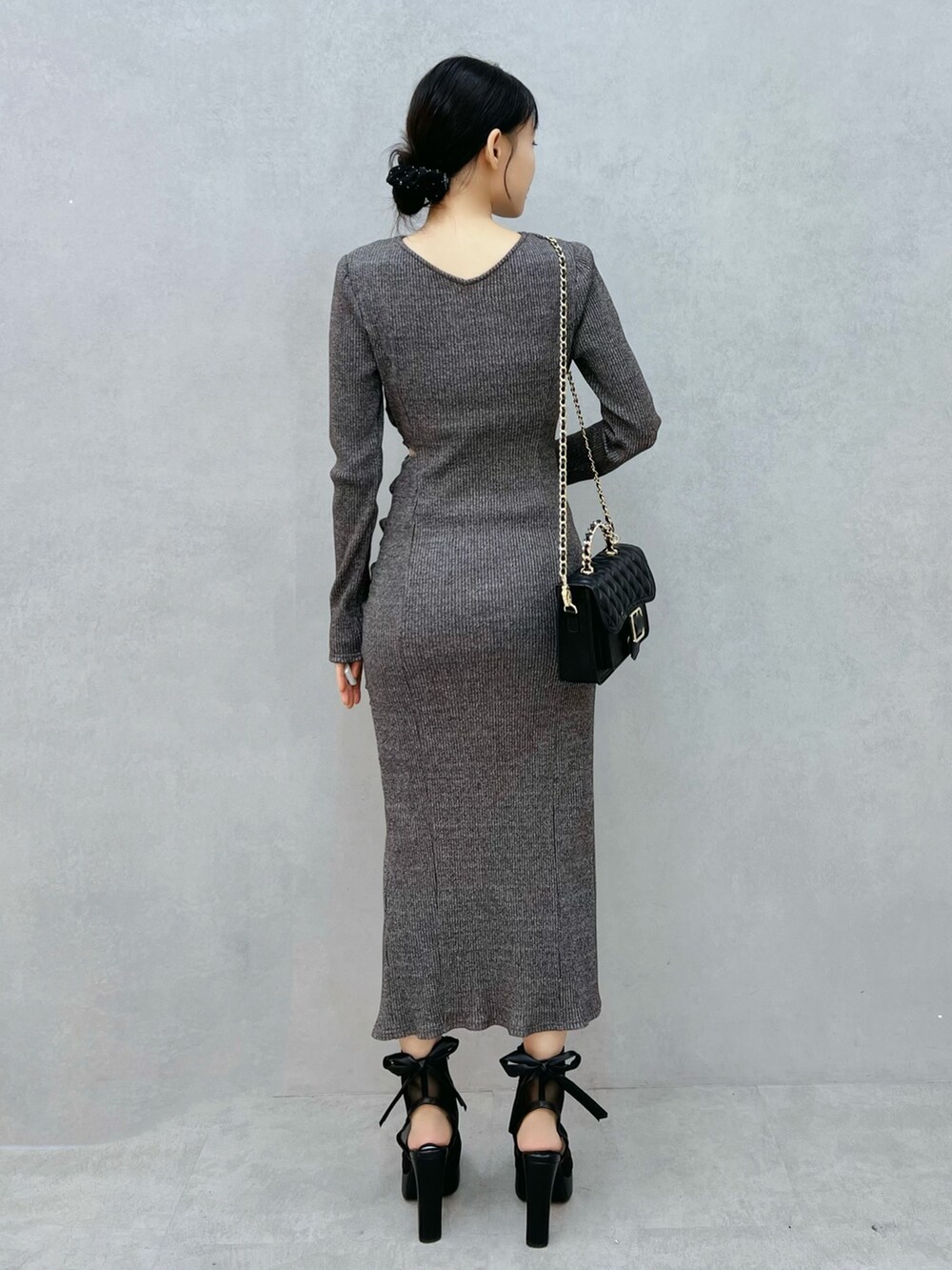 グレー系のワンピース、ブラック系のサンダル、ブラック系のショルダーバッグを着用したレディースの秋コーディネートの3枚目の写真