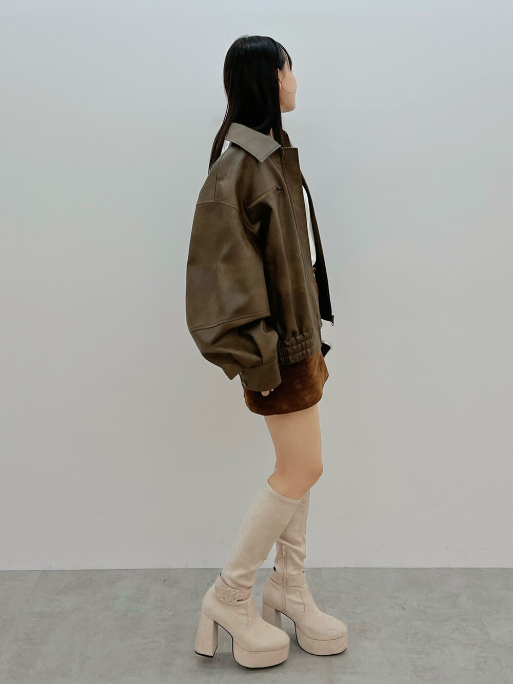 ブラウン系のブルゾン、ホワイト系のブーツを着用したレディースの秋コーディネートの4枚目の写真