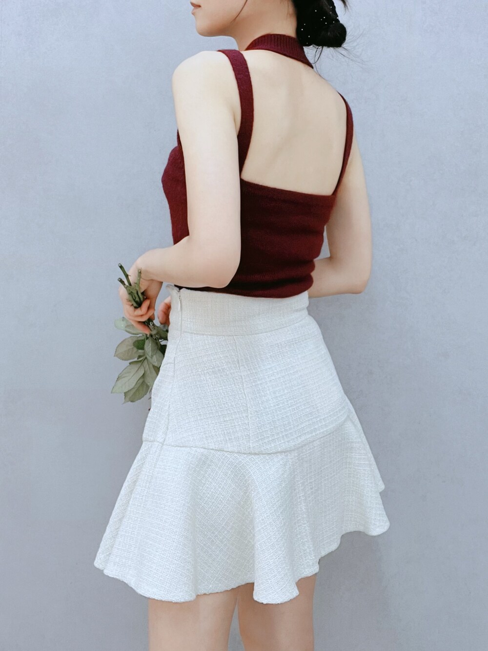 レッド系のニット/セーター、ホワイト系のスカート、ブラック系のブーツを着用したレディースの秋コーディネートの5枚目の写真