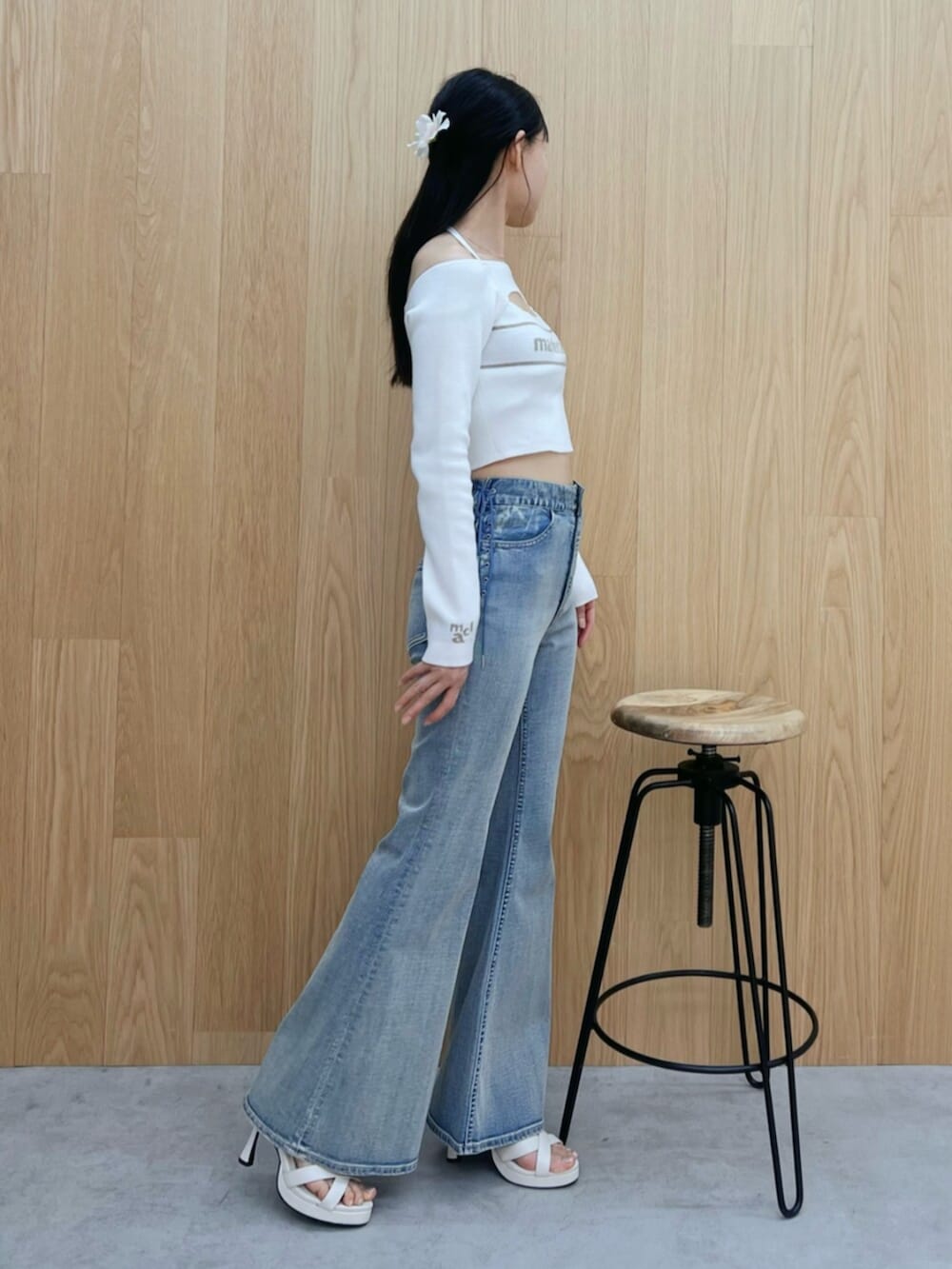 ブルー系のデニムパンツ、ホワイト系のサンダル、ホワイト系のニット/セーターを着用したレディースの春コーディネートの2枚目の写真