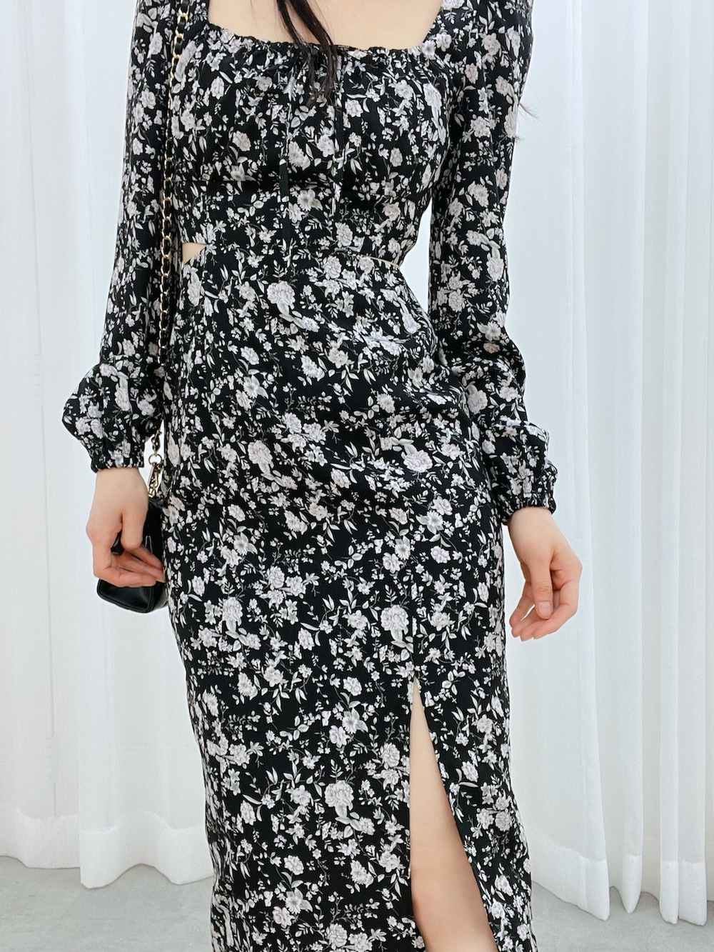 ブラック系のワンピース、ブラック系のサンダル、ブラック系のハンドバッグを着用したレディースの冬コーディネートの5枚目の写真