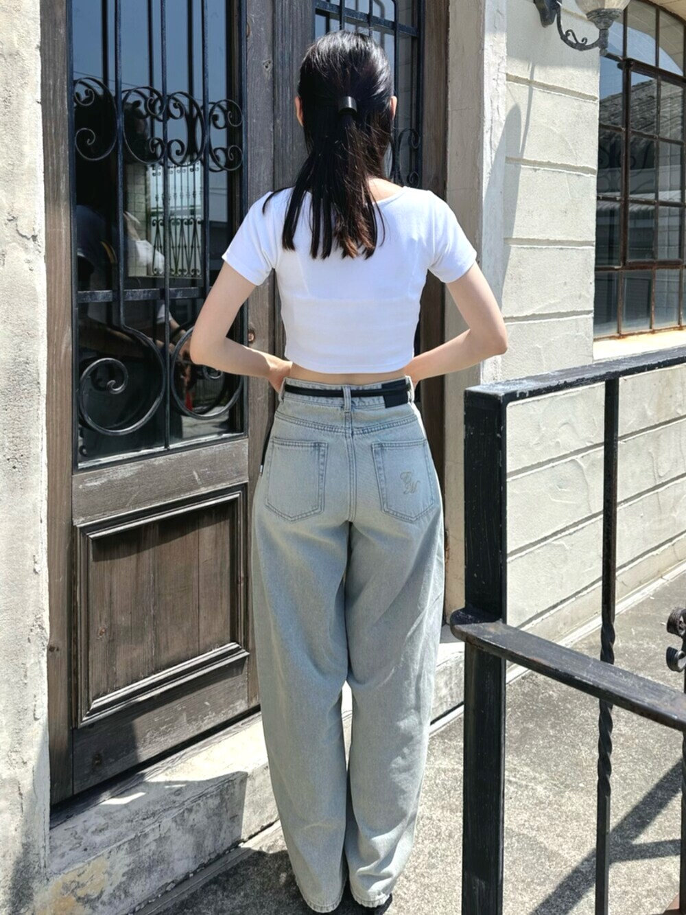 ホワイト系のTシャツ/カットソー、ブルー系のデニムパンツ、ブラック系のベルトを着用したレディースの夏コーディネートの4枚目の写真