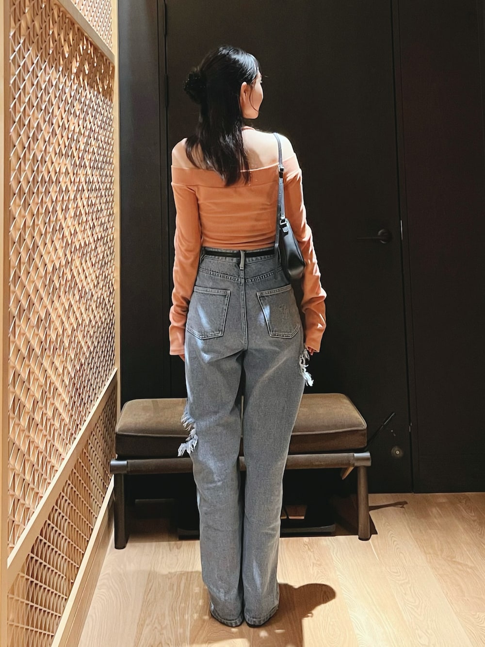 ブルー系のデニムパンツ、オレンジ系のTシャツ/カットソーを着用したレディースの秋コーディネートの3枚目の写真