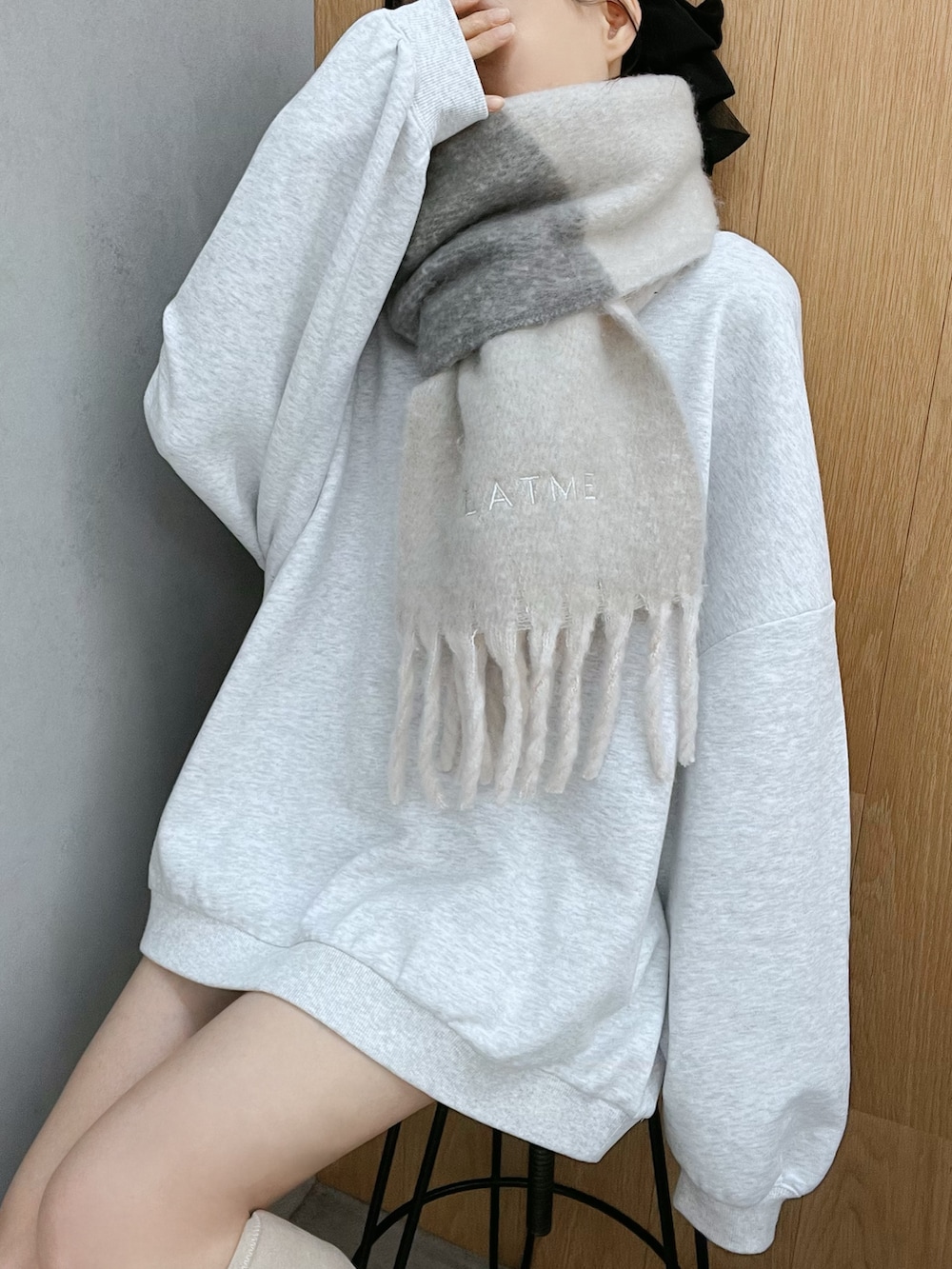 グレー系のスウェット、ホワイト系のブーツ、グレー系のマフラーを着用したレディースの秋コーディネートの6枚目の写真