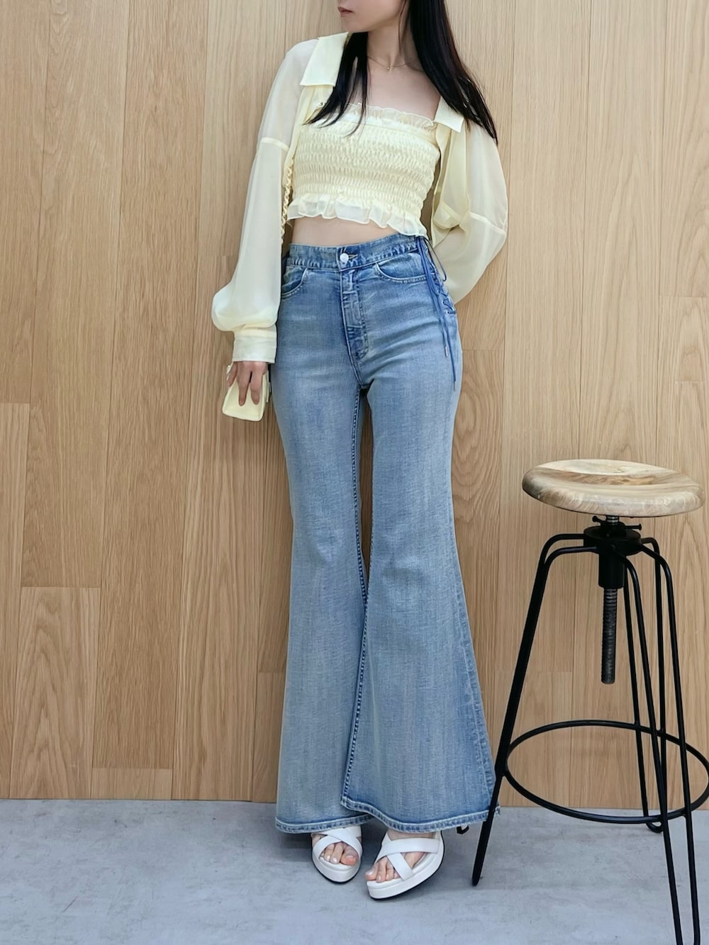 ホワイト系のサンダル、ブルー系のデニムパンツ、イエロー系のハンドバッグを着用したレディースの春コーディネートの4枚目の写真