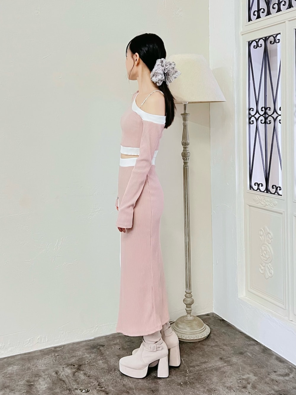 ピンク系のスカート、ピンク系のTシャツ/カットソー、ホワイト系のブーツを着用したレディースの冬コーディネートの2枚目の写真