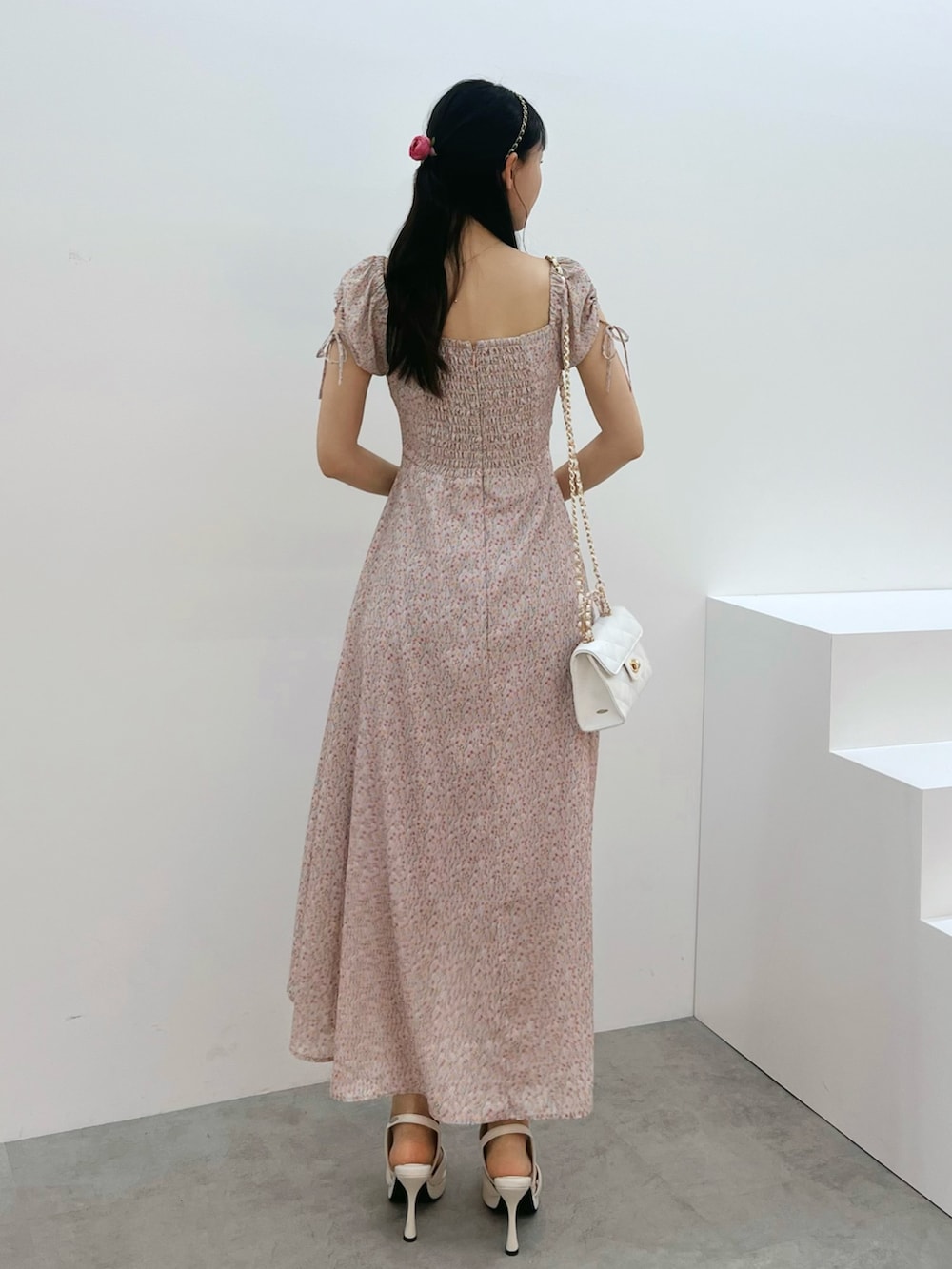 ピンク系のワンピース、ホワイト系のハンドバッグ、ホワイト系のサンダルを着用したレディースの春コーディネートの3枚目の写真