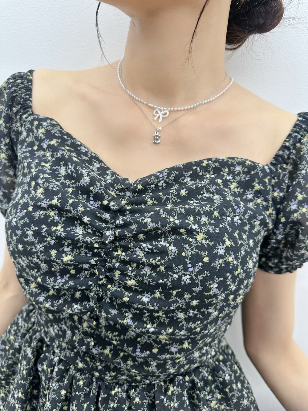 ブラック系のワンピース、ブルー系のデニムパンツ、シルバー系のネックレスを着用したレディースの夏コーディネートの5枚目の写真