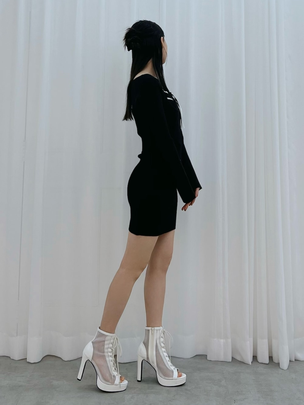 ブラック系のワンピース、ホワイト系のブーツを着用したレディースの冬コーディネートの2枚目の写真