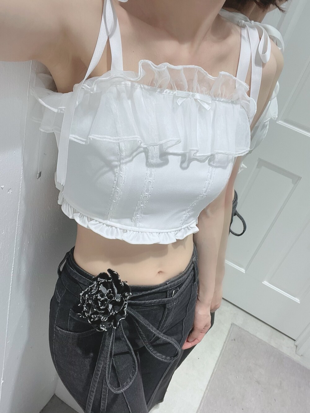 ブラック系のデニムパンツ、ブラック系のサンダル、ホワイト系のキャミソールを着用したレディースの春コーディネートの4枚目の写真