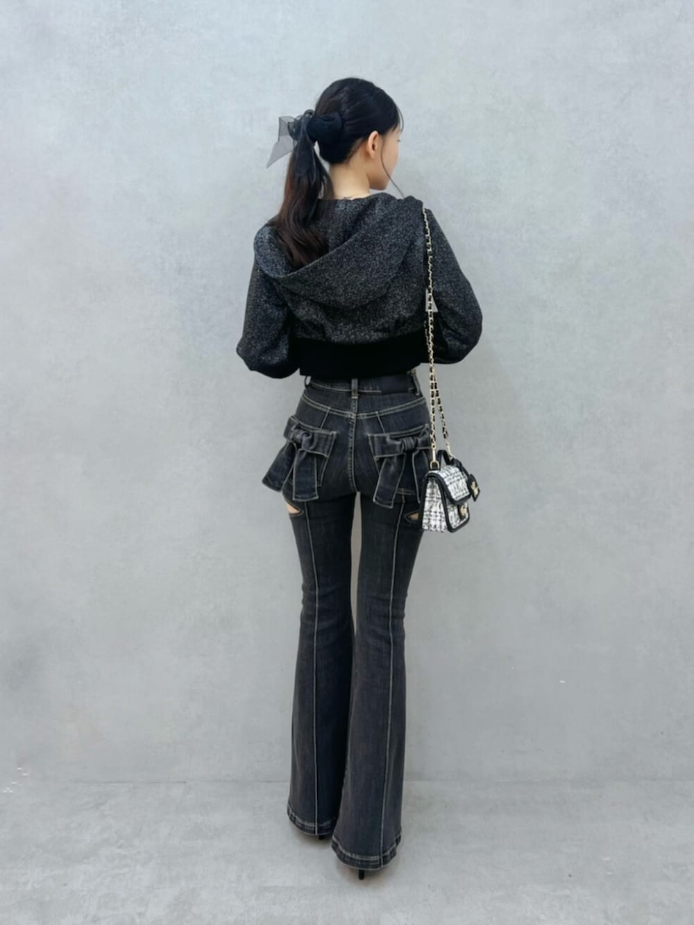 ブラック系のパーカー、ブラック系のパンプス、ブラック系のデニムパンツを着用したレディースの夏コーディネートの3枚目の写真