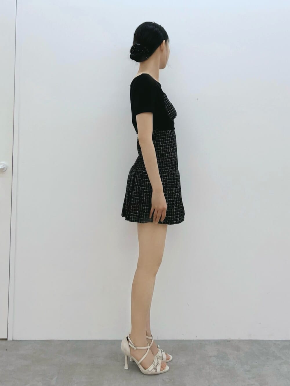 ホワイト系のサンダル、ブラック系のワンピース、ブラック系のTシャツ/カットソーを着用したレディースの夏コーディネートの3枚目の写真