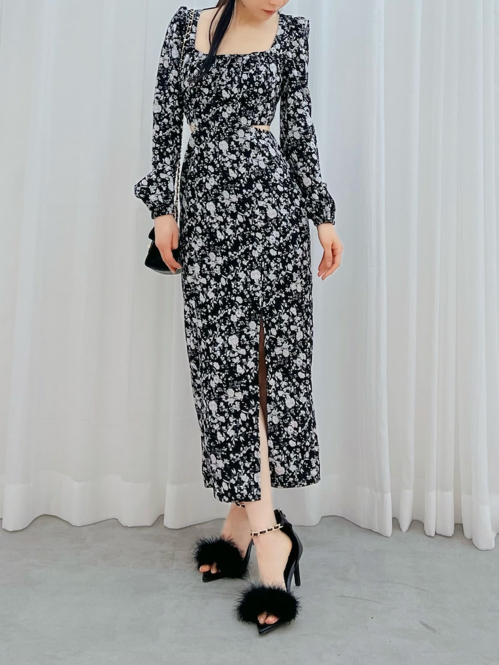 ブラック系のワンピース、ブラック系のサンダル、ブラック系のハンドバッグを着用したレディースの冬コーディネートの4枚目の写真