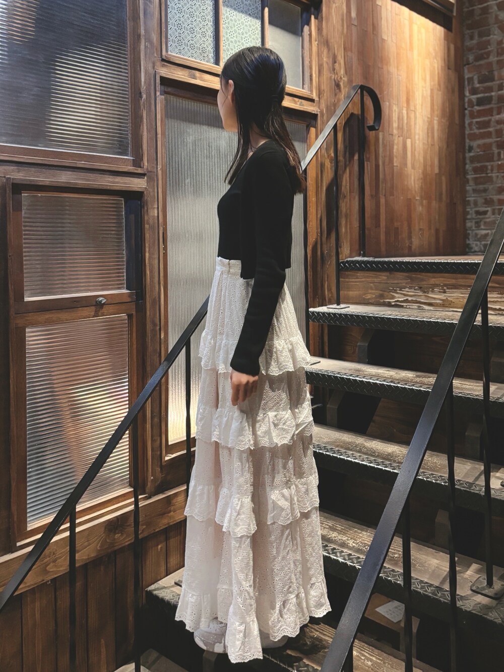 ホワイト系のスカート、ブラック系のTシャツ/カットソーを着用したレディースの夏コーディネートの2枚目の写真