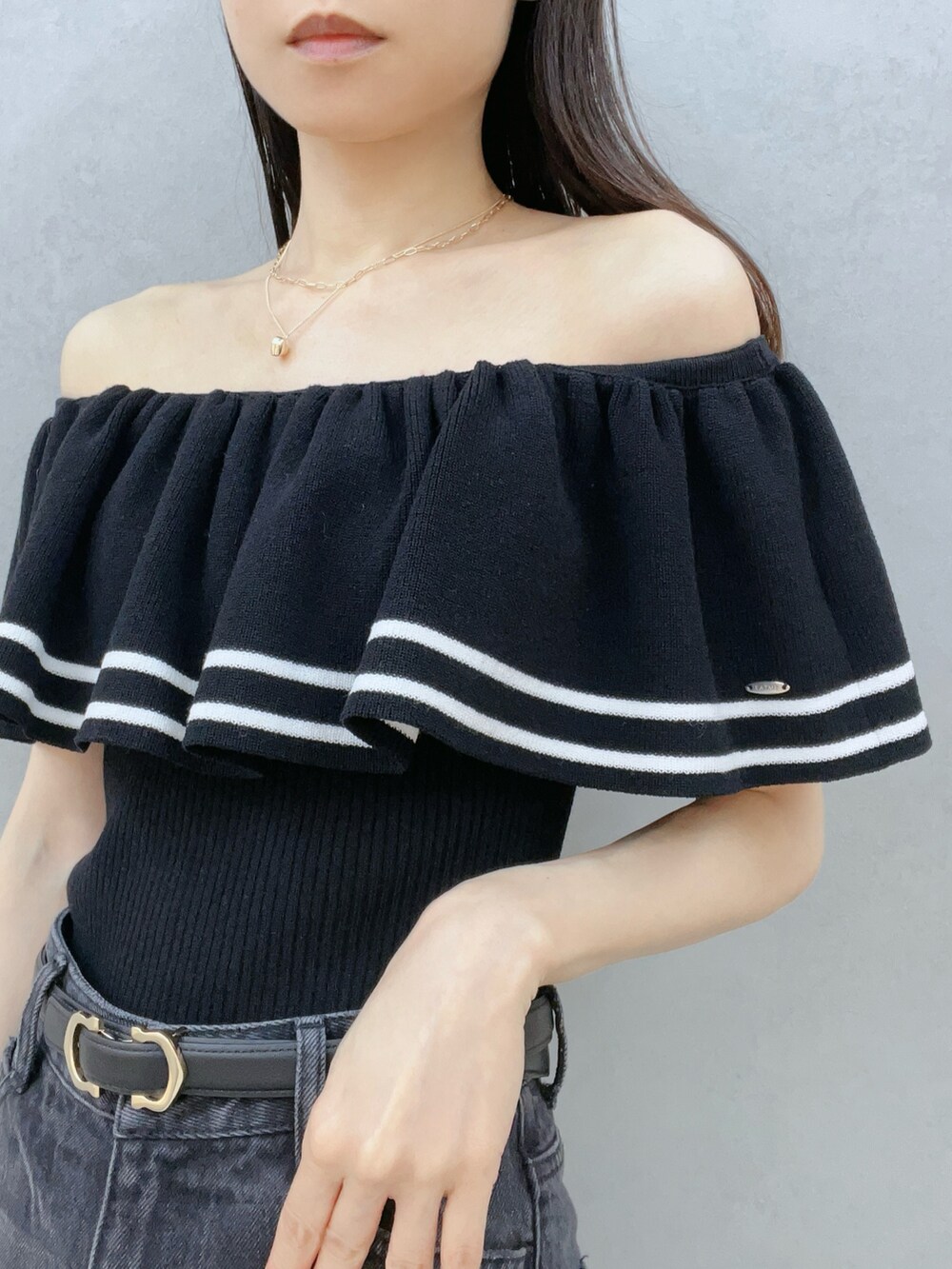 ブラック系のニット/セーター、ブラック系のサングラス、ブラック系のベルトを着用したレディースの夏コーディネートの7枚目の写真