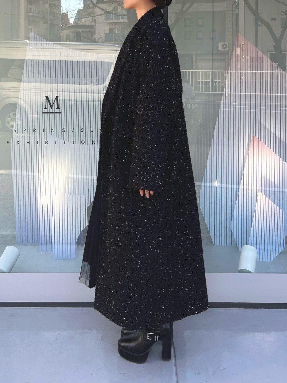 ピンク系のハンドバッグ、ブラック系のチェスターコート、ブラック系のブーツを着用したレディースの冬コーディネートの5枚目の写真