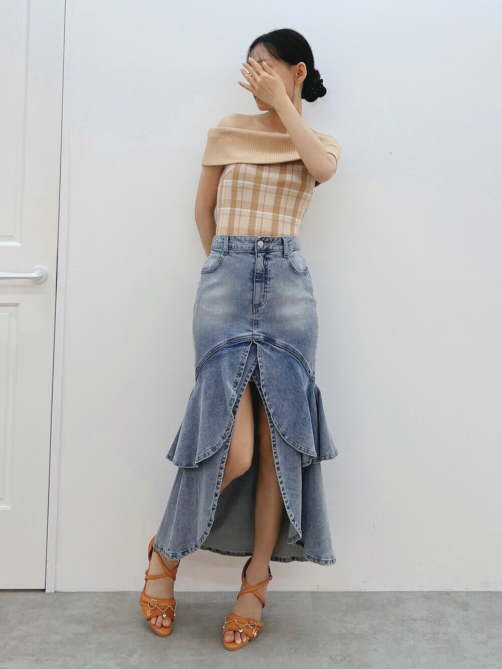 オレンジ系のワンピース、オレンジ系のサンダル、ブルー系のデニムスカートを着用したレディースの夏コーディネートの2枚目の写真