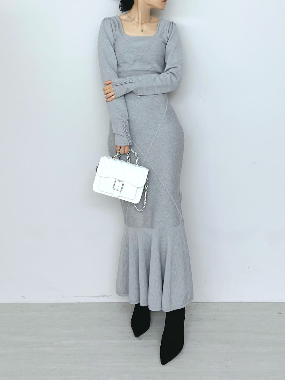 ホワイト系のショルダーバッグ、グレー系のニット/セーター、グレー系のスカートを着用したレディースの秋コーディネートの8枚目の写真