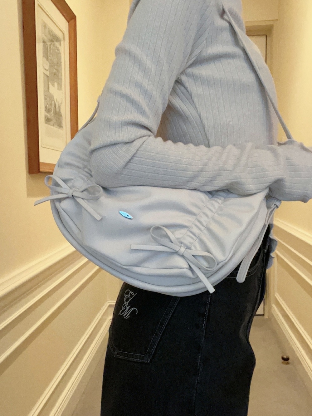 ブラック系のデニムパンツ、ホワイト系のショルダーバッグ、ホワイト系のTシャツ/カットソーを着用したレディースの冬コーディネートの5枚目の写真