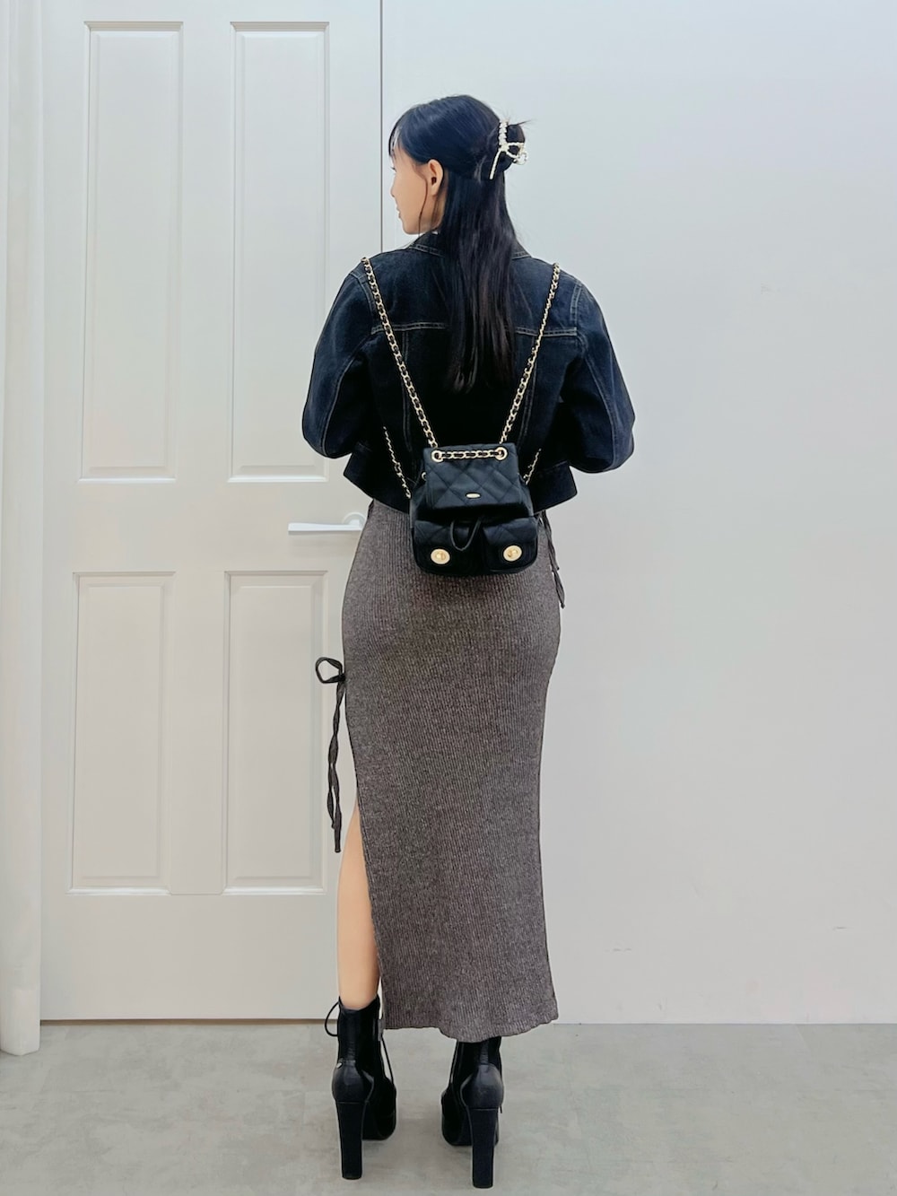 グレー系のワンピース、ブラック系のブーツ、ブラック系のデニムジャケットを着用したレディースの春コーディネートの3枚目の写真