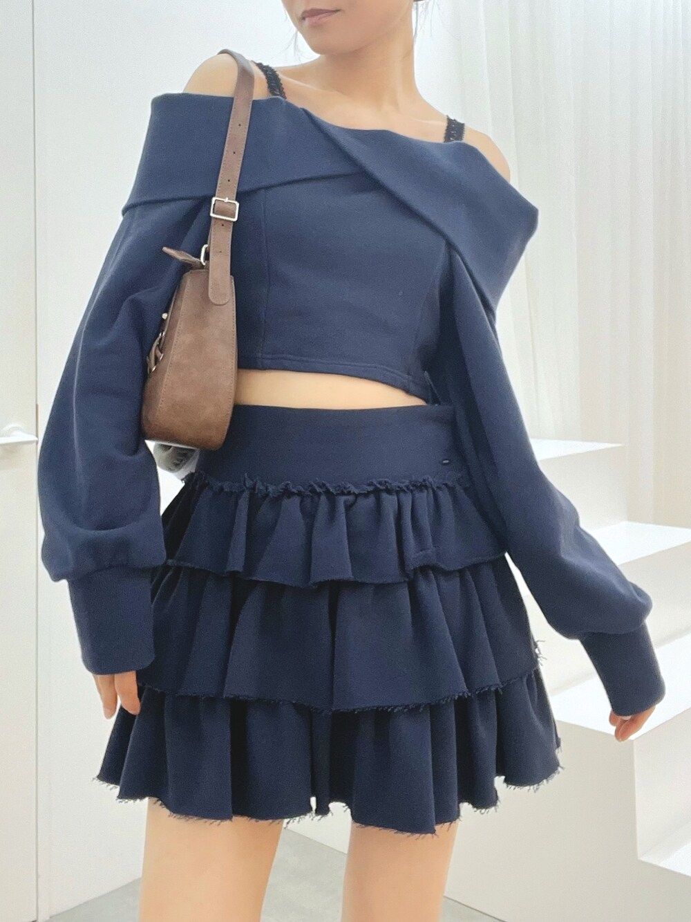 ブルー系のスカート、ブルー系のTシャツ/カットソー、ブラック系のブーツを着用したレディースの秋コーディネートの5枚目の写真