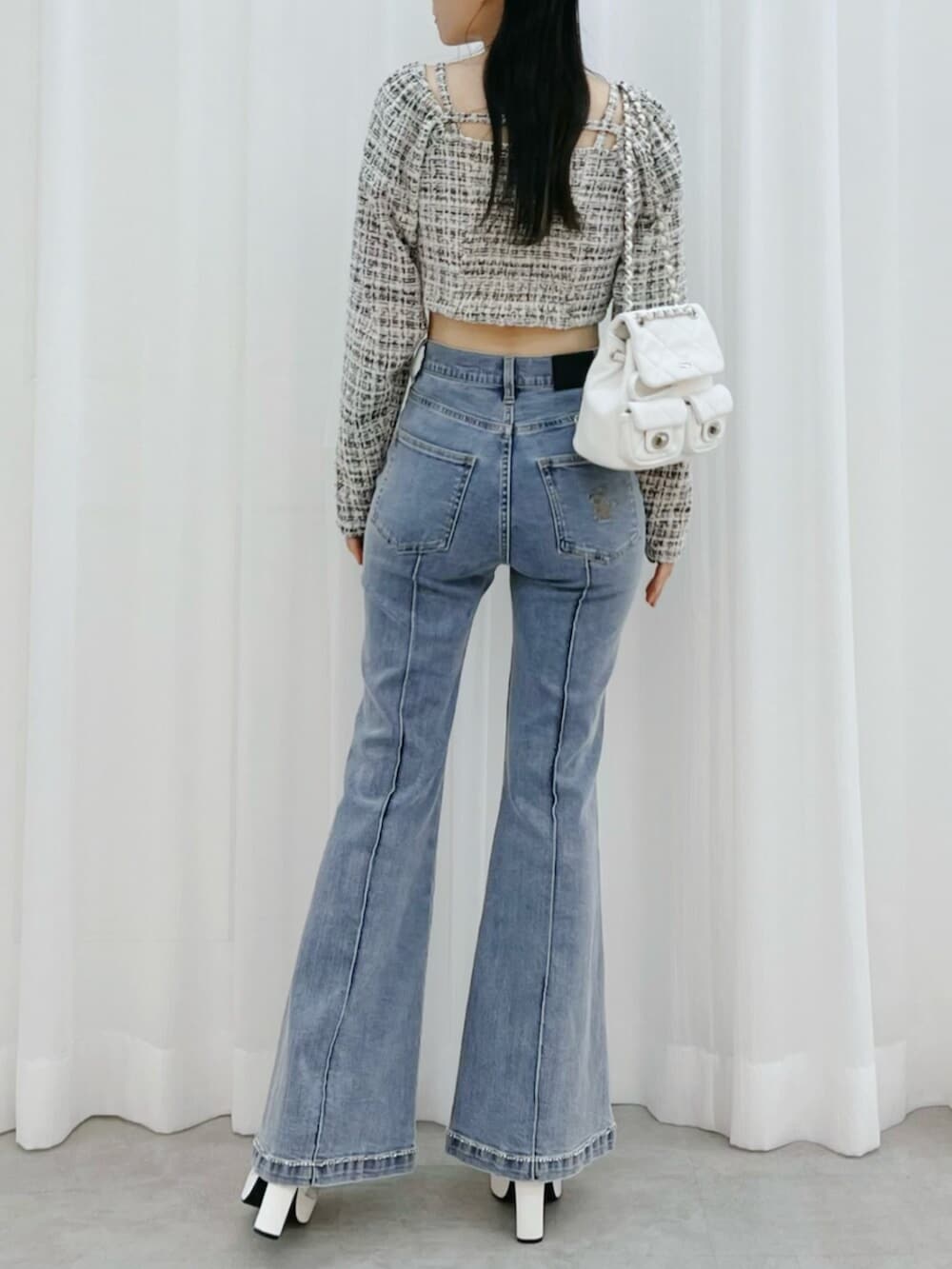 ホワイト系のブーツ、ブルー系のデニムパンツ、ブラック系のシャツ/ブラウスを着用したレディースの冬コーディネートの3枚目の写真