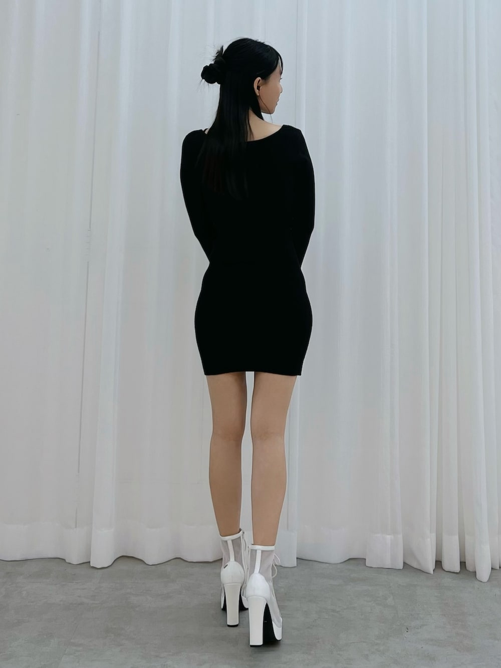 ブラック系のワンピース、ホワイト系のブーツを着用したレディースの冬コーディネートの3枚目の写真