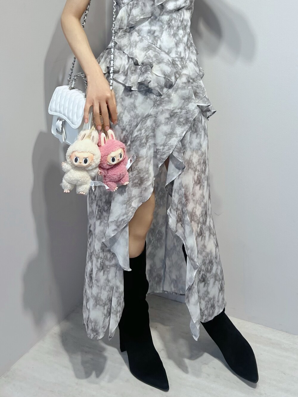 グレー系のワンピース、ホワイト系のショルダーバッグ、その他のブーツを着用したレディースの夏コーディネートの5枚目の写真