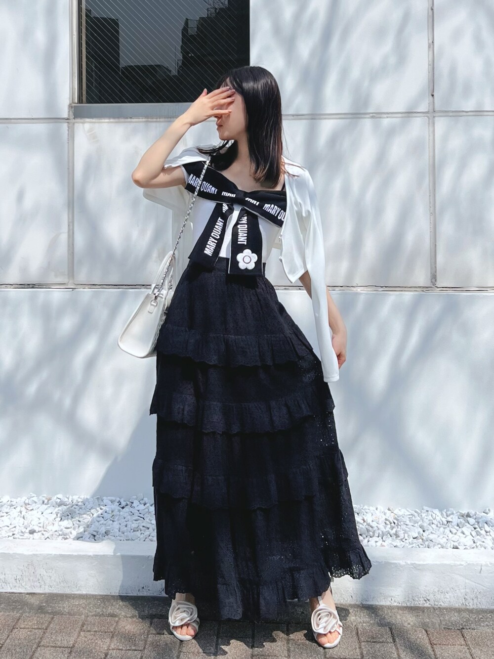 ブラック系のスカート、ホワイト系のワンピース、ホワイト系のサンダルを着用したレディースの春コーディネートの7枚目の写真