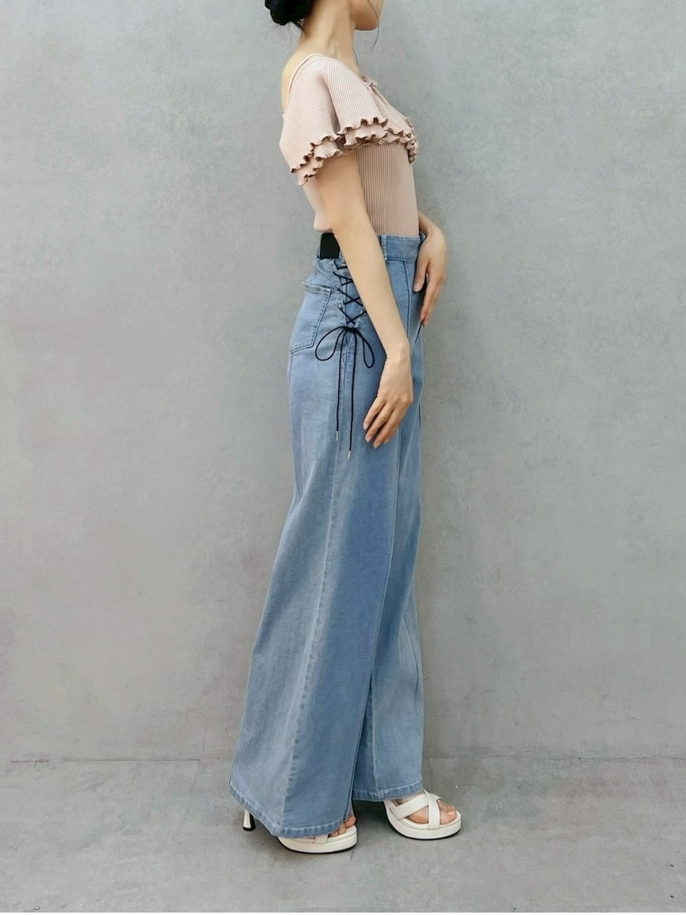ブルー系のデニムパンツ、ピンク系のTシャツ/カットソー、ホワイト系のサンダルを着用したレディースの夏コーディネートの2枚目の写真
