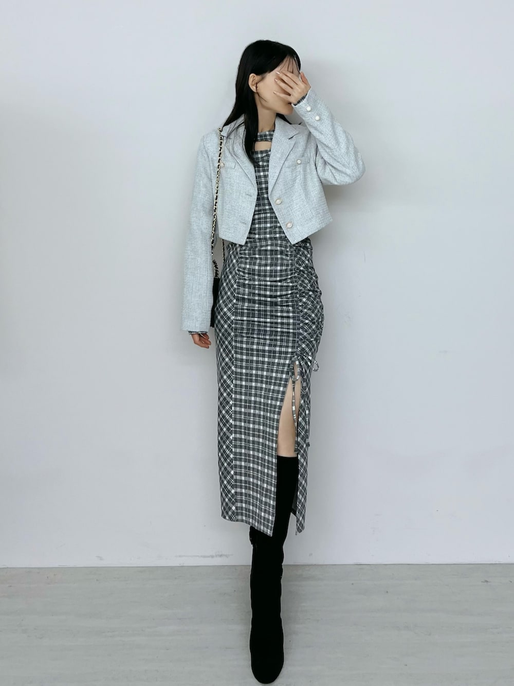 グレー系のワンピース、ブラック系のブーツ、グレー系のテーラードジャケットを着用したレディースの秋コーディネートの2枚目の写真