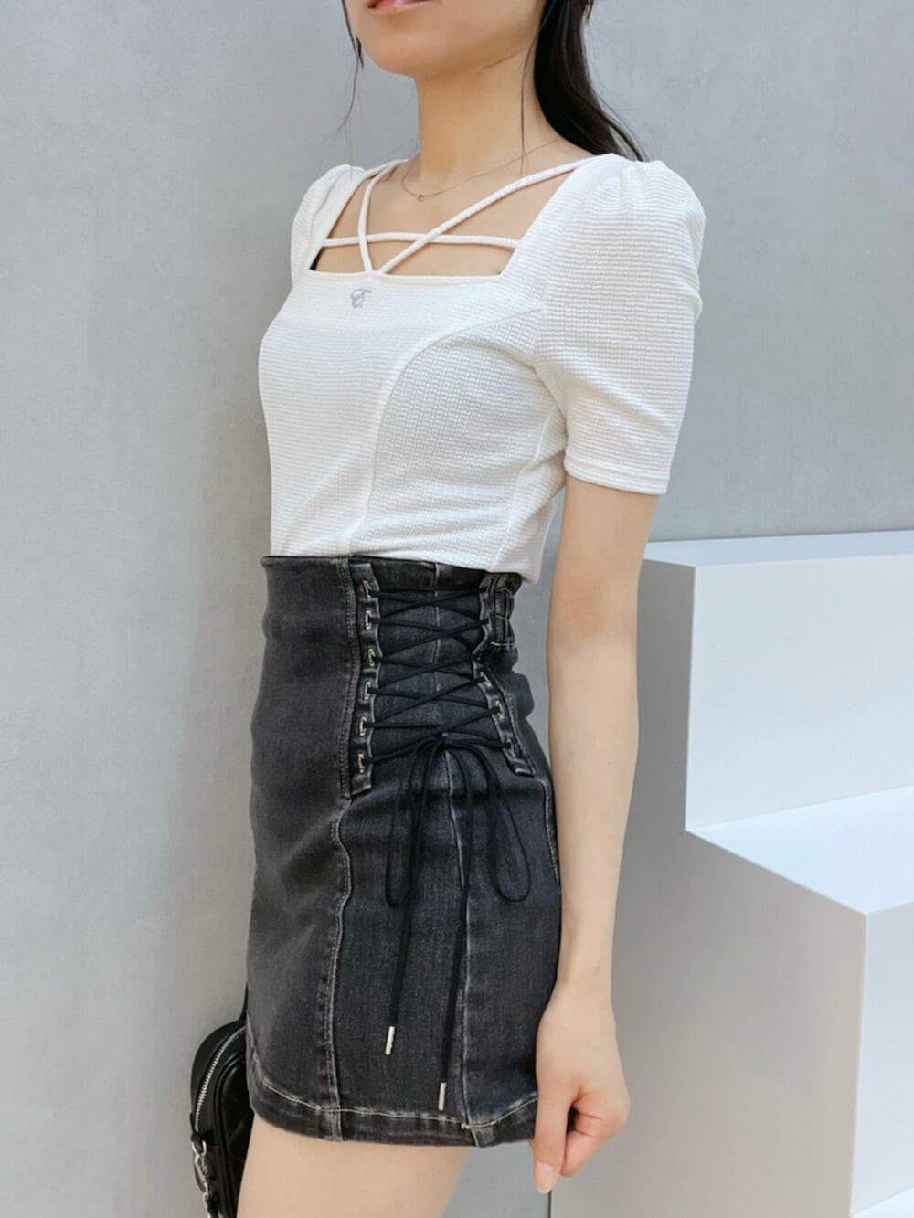 ブラック系のサンダル、ブラック系のデニムスカート、ホワイト系のTシャツ/カットソーを着用したレディースの夏コーディネートの6枚目の写真