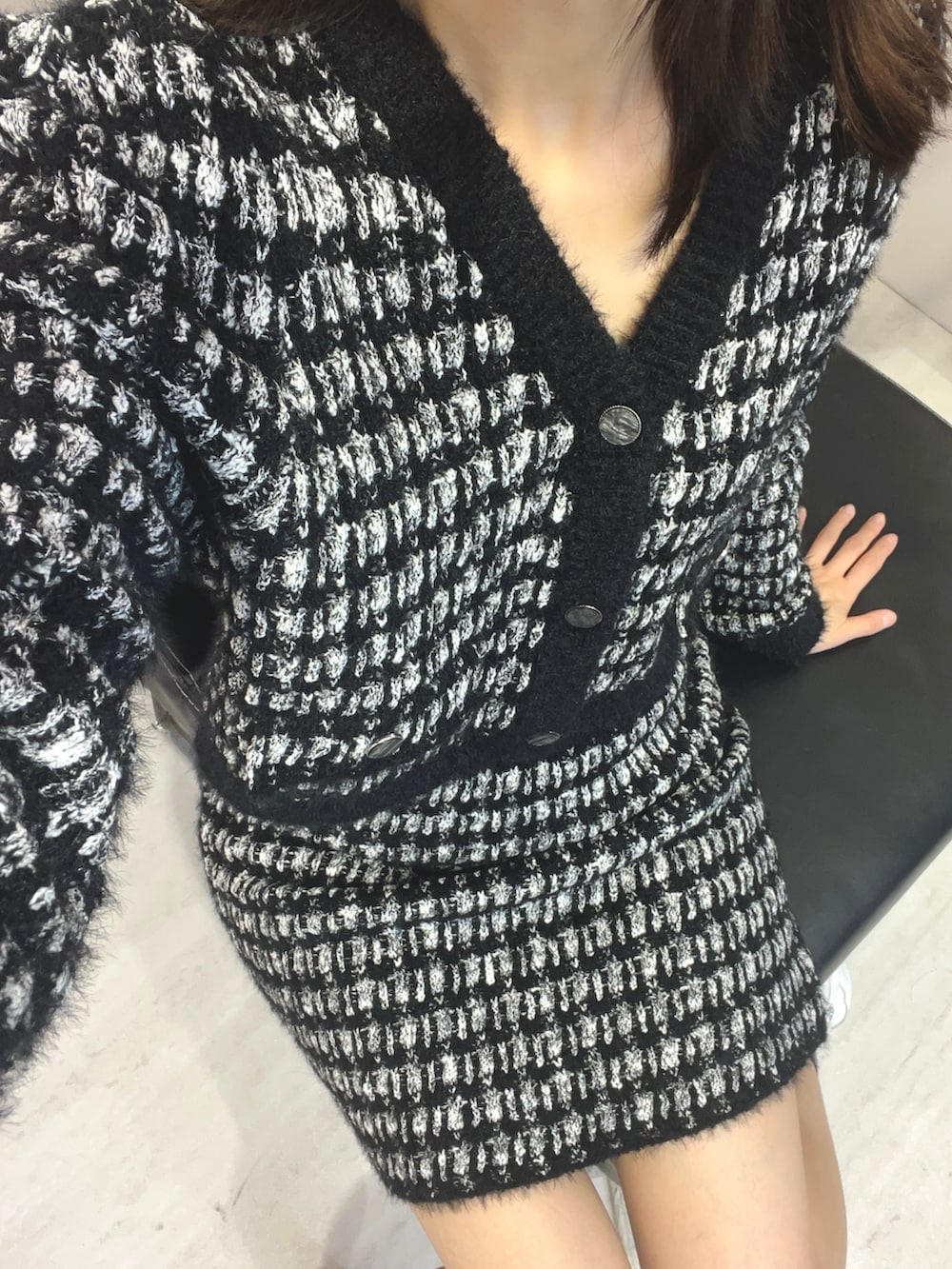 ブラック系のカーディガン/ボレロ、ブラック系のスカートを着用したレディースの冬コーディネートの2枚目の写真