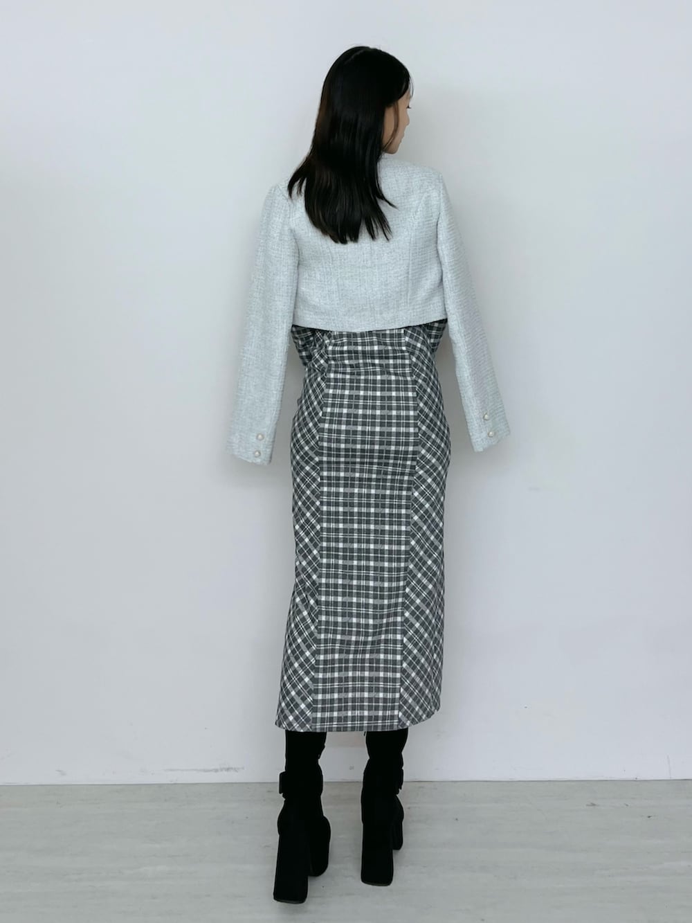 グレー系のワンピース、ブラック系のブーツ、グレー系のテーラードジャケットを着用したレディースの秋コーディネートの4枚目の写真