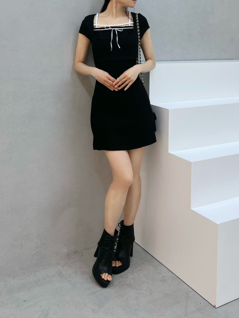 ブラック系のサンダル、ブラック系のワンピース、ブラック系のハンドバッグを着用したレディースの夏コーディネートの4枚目の写真