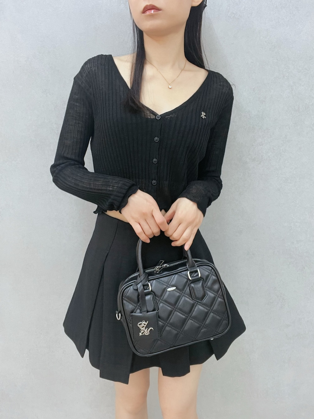 ブラック系のスカート、ブラック系のカーディガン/ボレロ、ブラック系のサンダルを着用したレディースの春コーディネートの5枚目の写真
