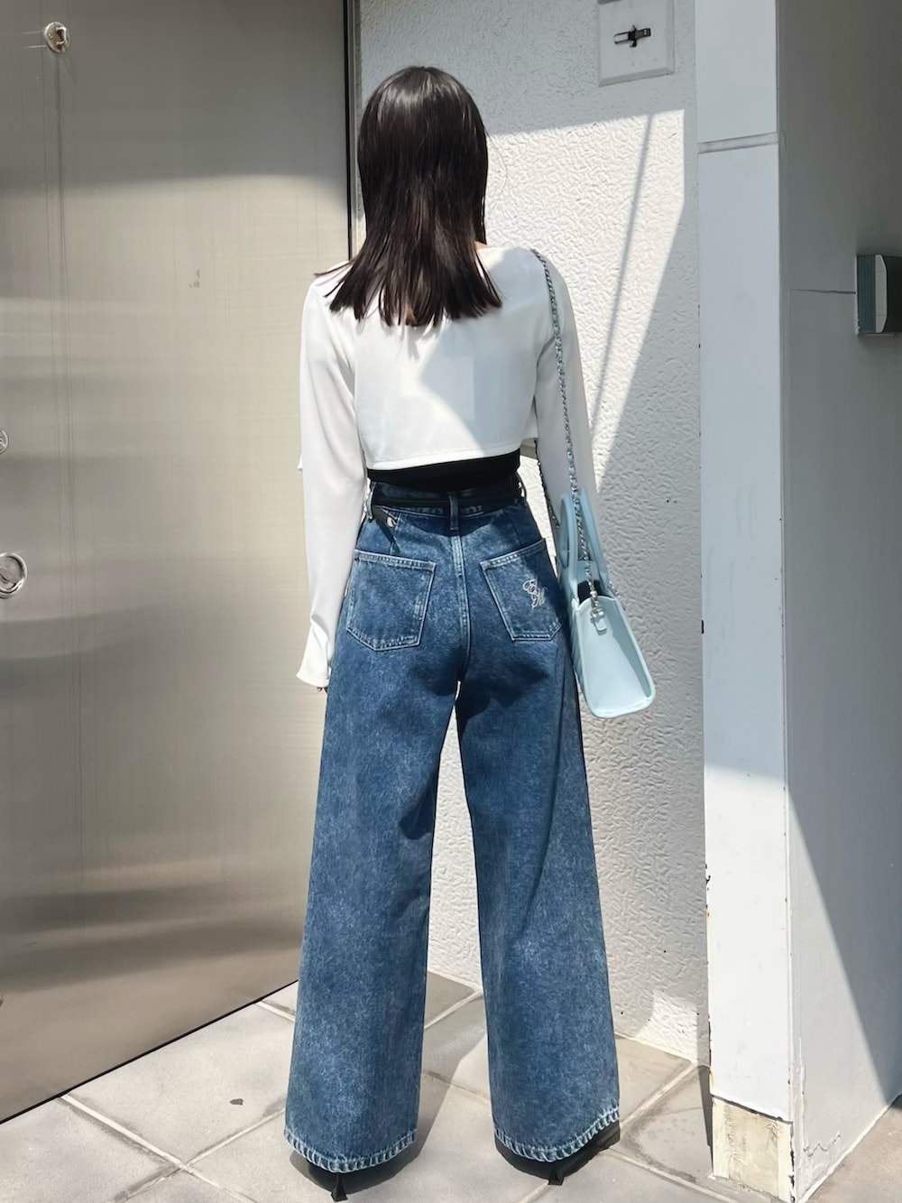 ブラック系のワンピース、ホワイト系のTシャツ/カットソー、ブルー系のハンドバッグを着用したレディースの春コーディネートの6枚目の写真