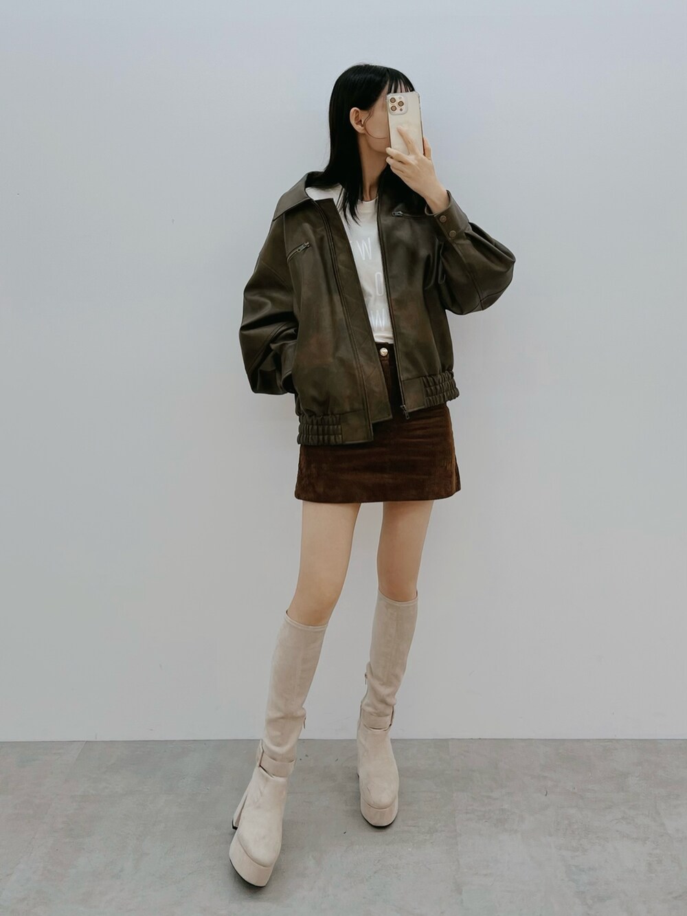 ブラウン系のブルゾン、ホワイト系のブーツを着用したレディースの秋コーディネートの3枚目の写真