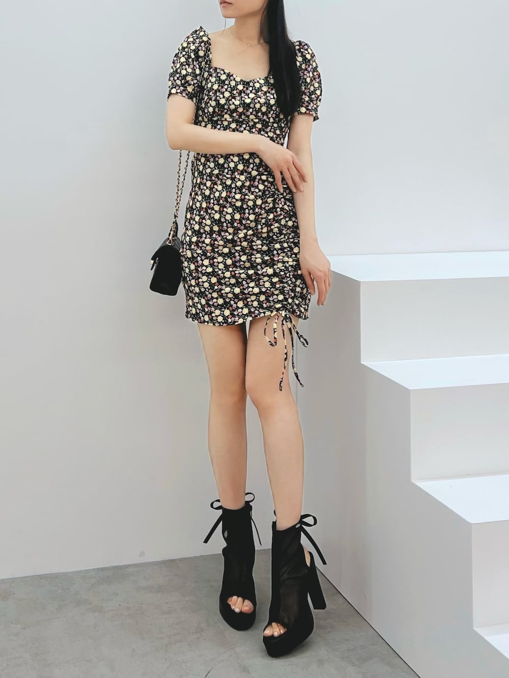 ブラック系のワンピース、ブラック系のハンドバッグ、ブラック系のサンダルを着用したレディースの春コーディネートの4枚目の写真