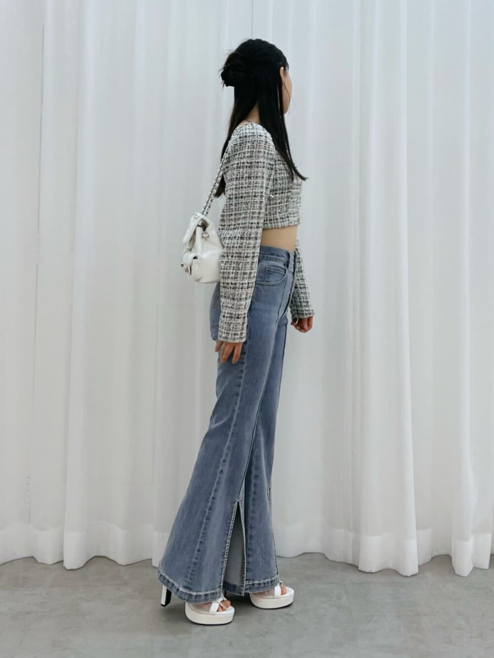 ホワイト系のブーツ、ブルー系のデニムパンツ、ブラック系のシャツ/ブラウスを着用したレディースの冬コーディネートの2枚目の写真