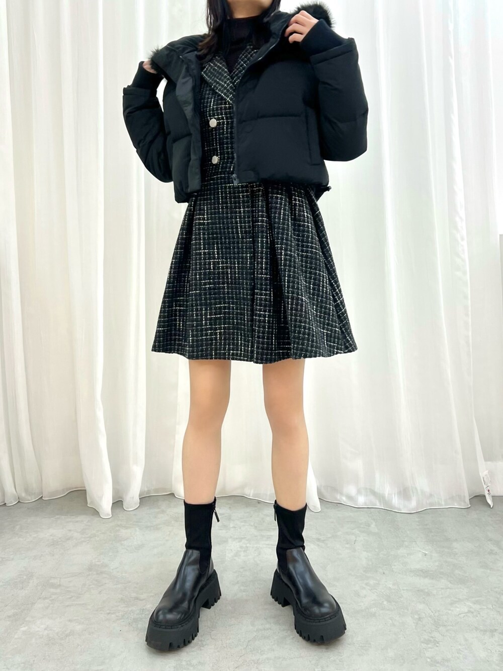 ブラック系のワンピース、ホワイト系のハンドバッグを着用したレディースの冬コーディネートの5枚目の写真