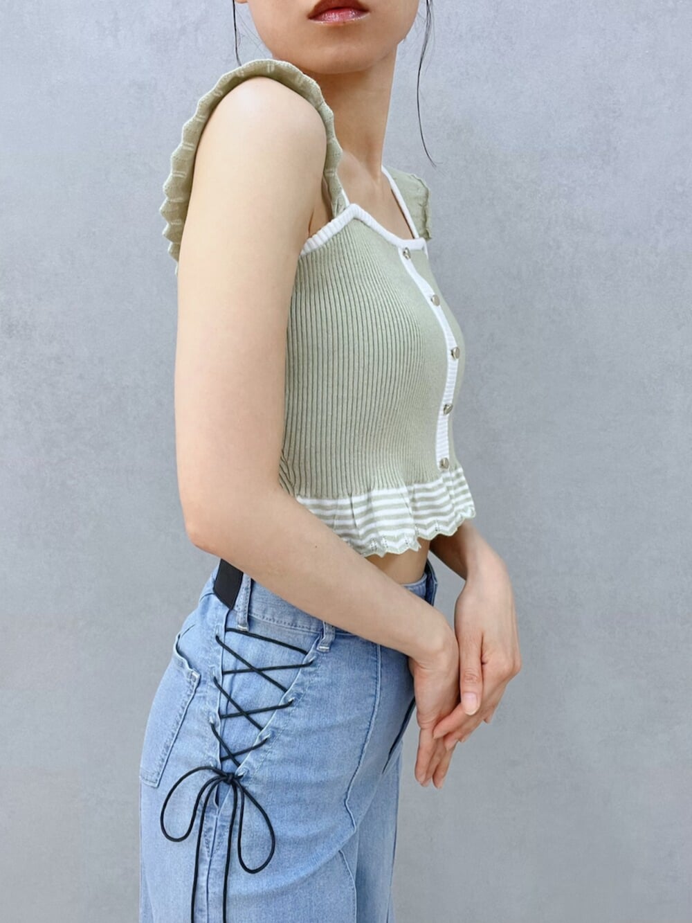 ホワイト系のサンダル、ブルー系のデニムパンツ、グリーン系のキャミソールを着用したレディースの夏コーディネートの10枚目の写真