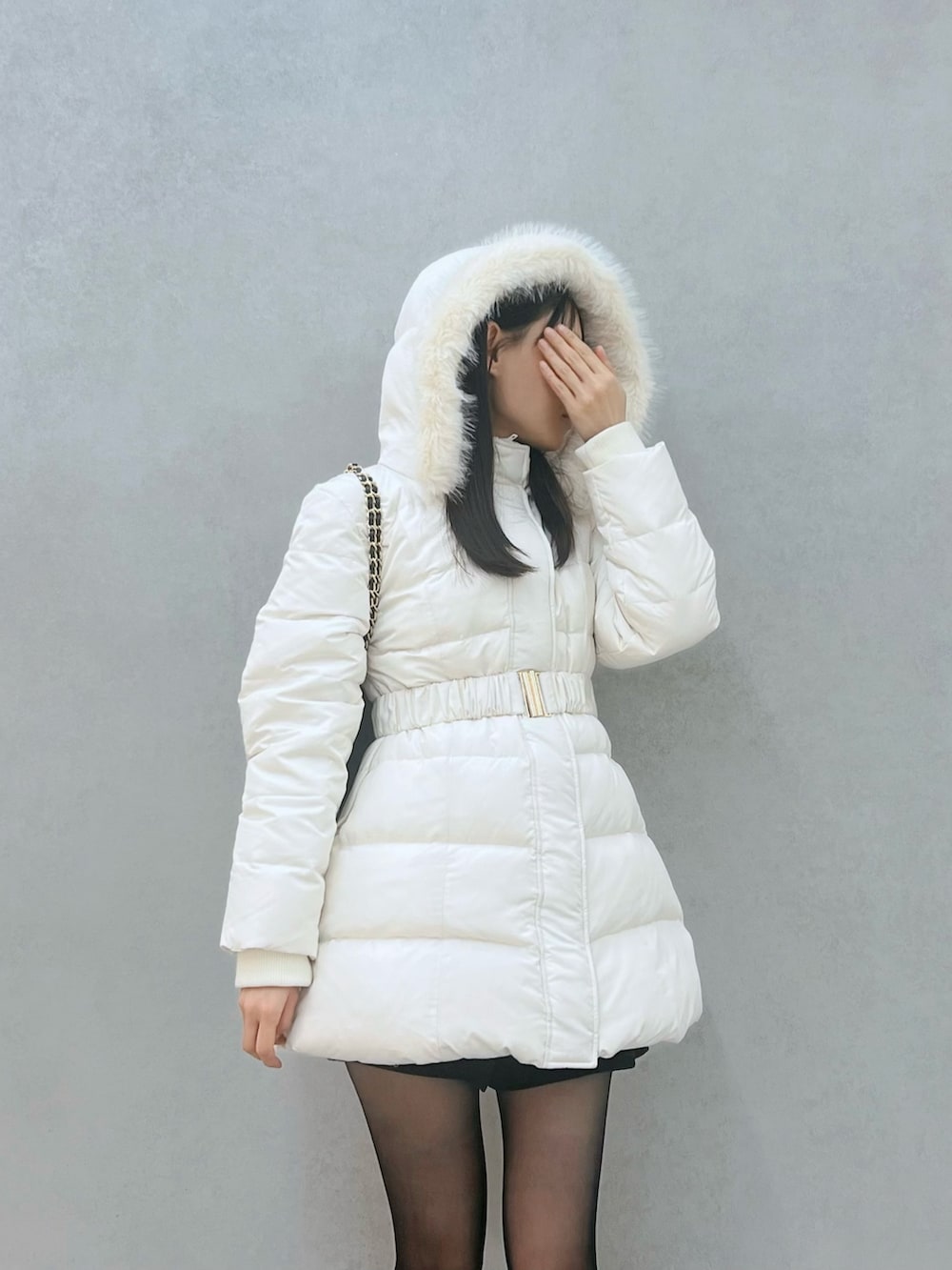 ブラック系のダウンジャケット/コート、ブラック系のブーツ、ブラック系のハンドバッグを着用したレディースの秋コーディネートの5枚目の写真