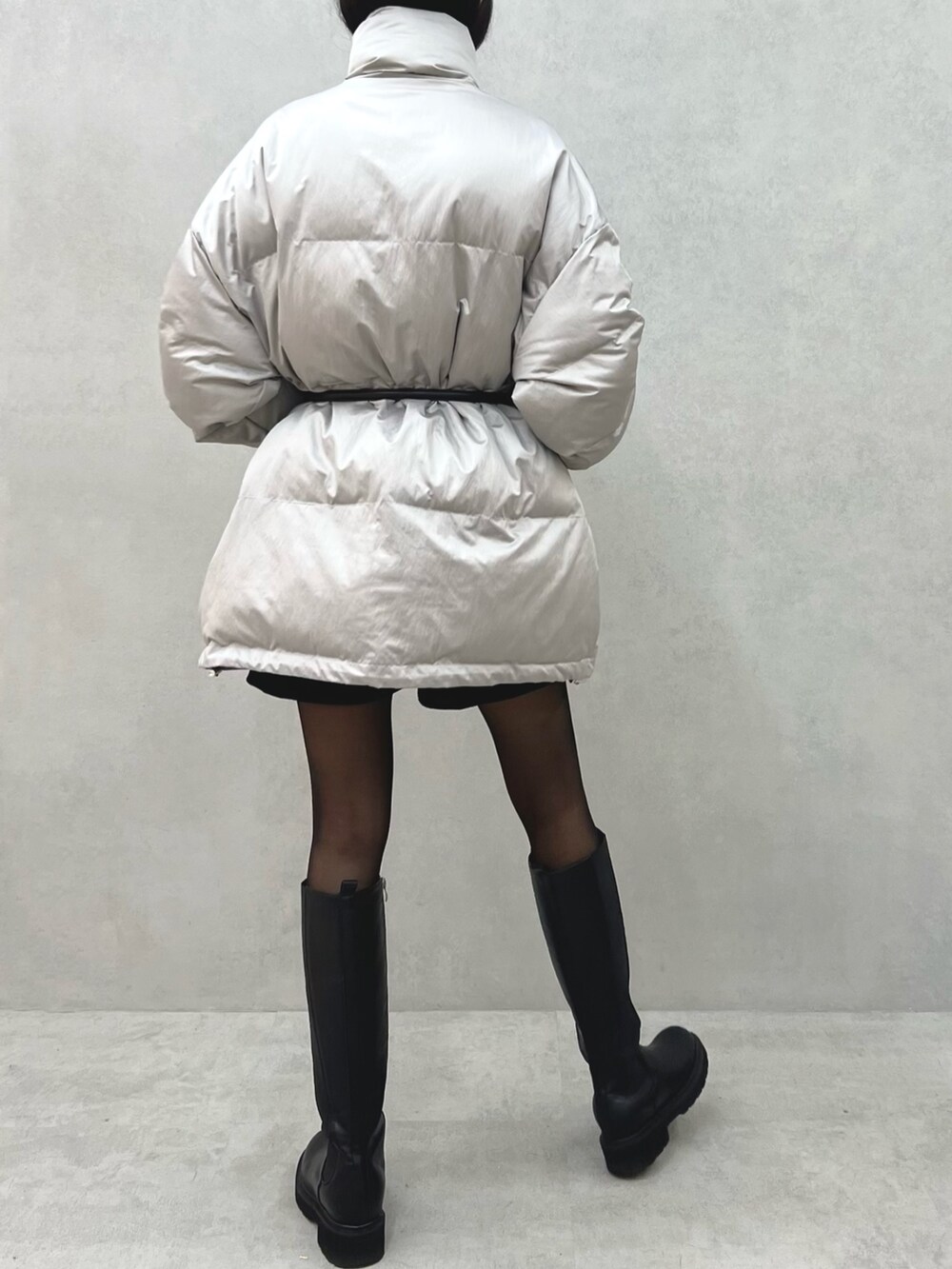 グレー系のブルゾン、ブラック系のハンドバッグ、ブラック系のベルトを着用したレディースの冬コーディネートの4枚目の写真