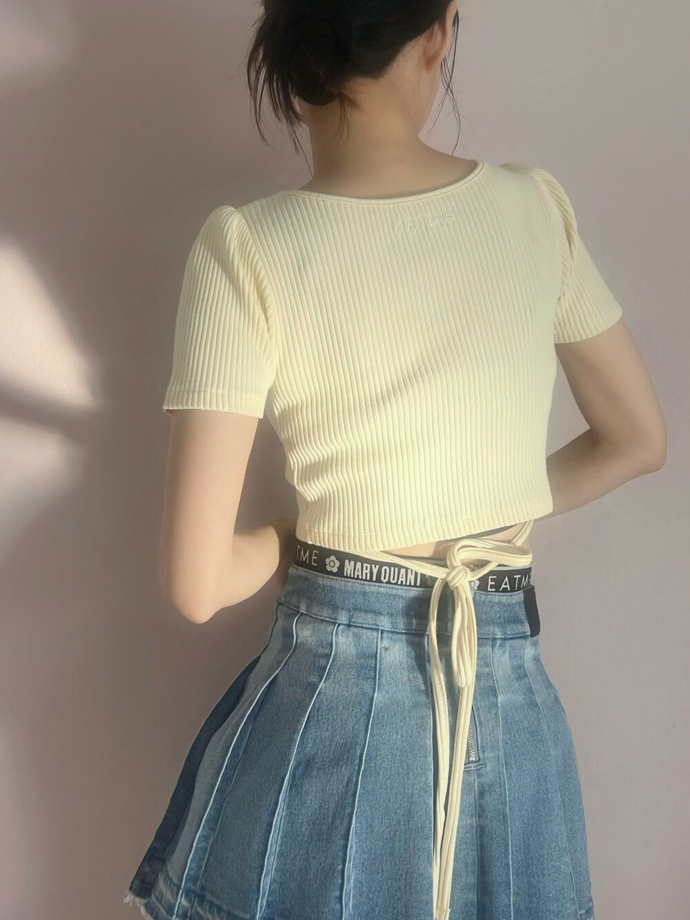 イエロー系のTシャツ/カットソー、ブルー系のデニムスカートを着用したレディースの春コーディネートの6枚目の写真