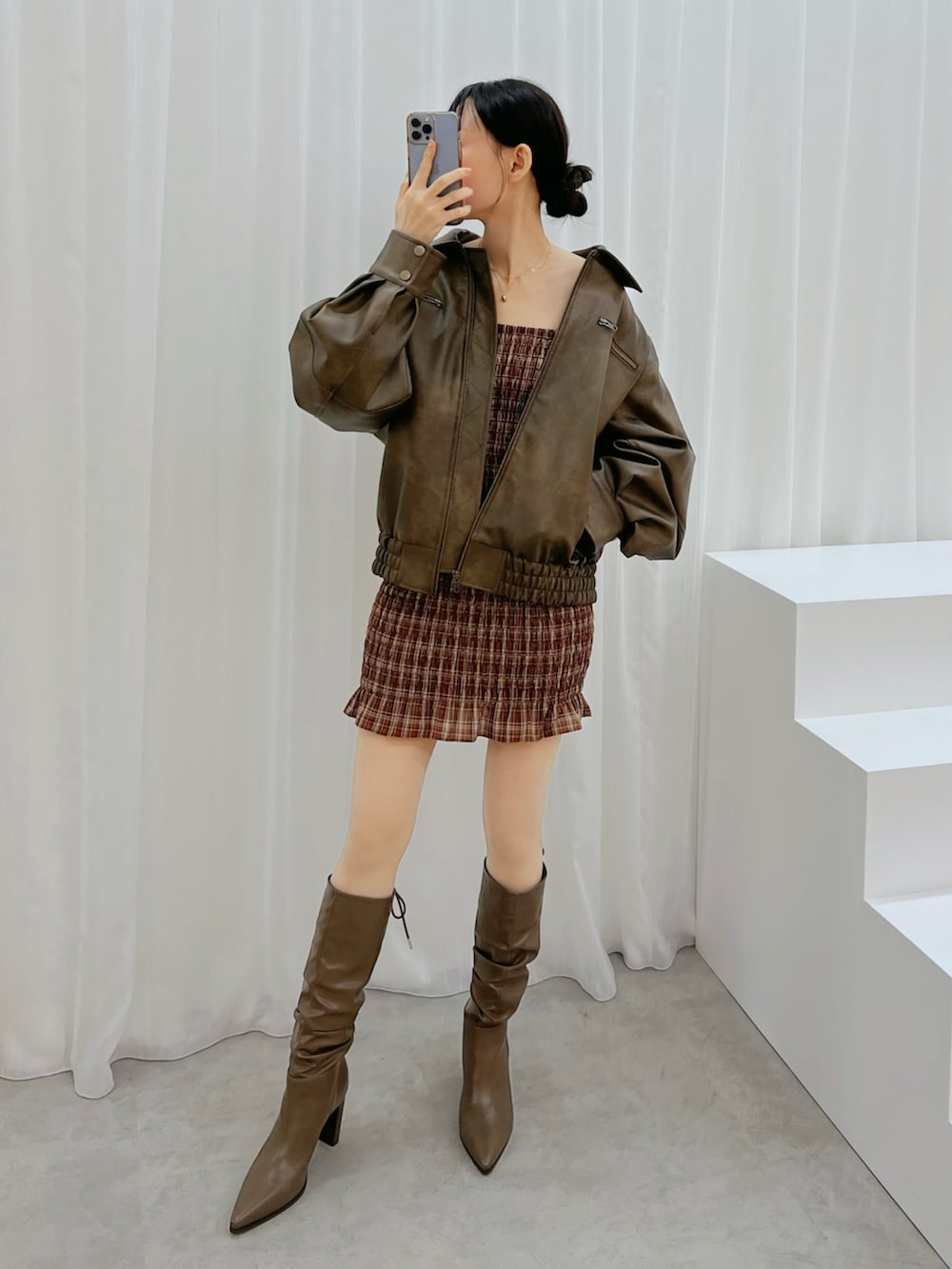 レッド系のワンピース、ブラウン系のブルゾン、ブラウン系のブーツを着用したレディースの秋コーディネートの4枚目の写真