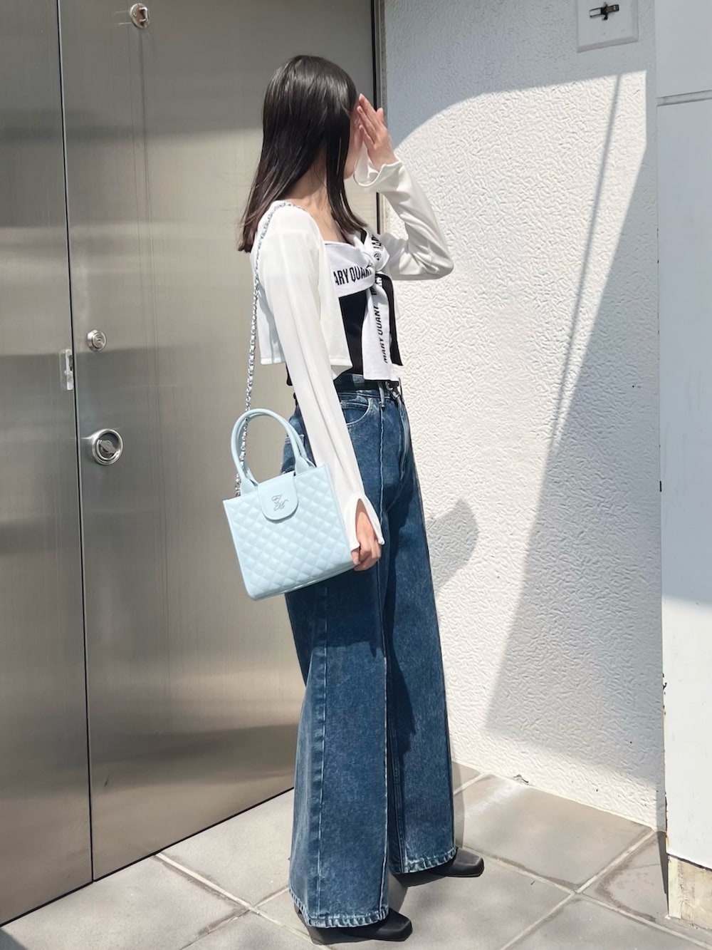 ブラック系のワンピース、ホワイト系のTシャツ/カットソー、ブルー系のハンドバッグを着用したレディースの春コーディネートの7枚目の写真