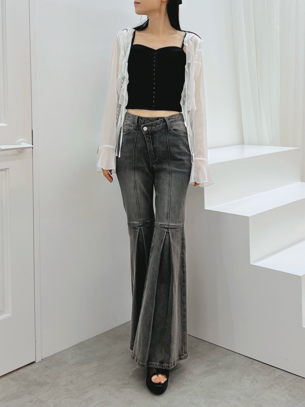 ブラック系のデニムパンツ、ブラック系のキャミソール、ホワイト系のカーディガン/ボレロを着用したレディースの秋コーディネートの6枚目の写真